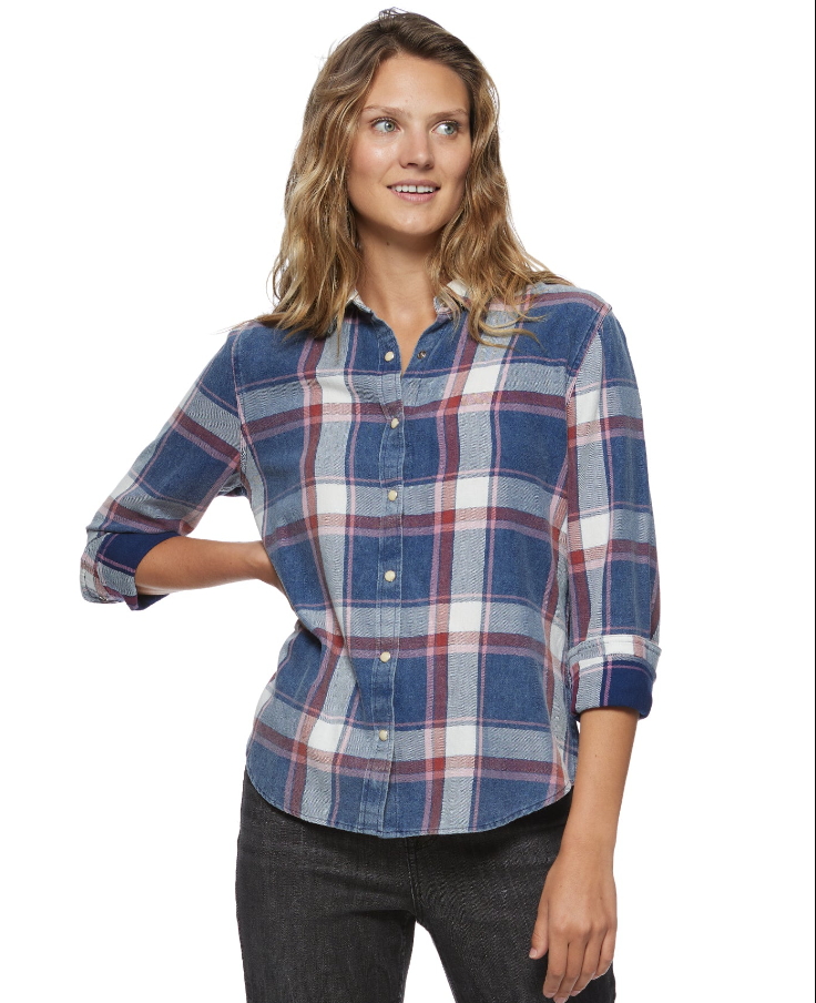 A woman wearing a blue and red plaid shirt with a collared neckline and long sleeves.