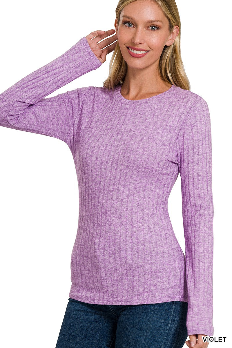 A woman wearing a purple long sleeve round neck top with ribbed detailing.